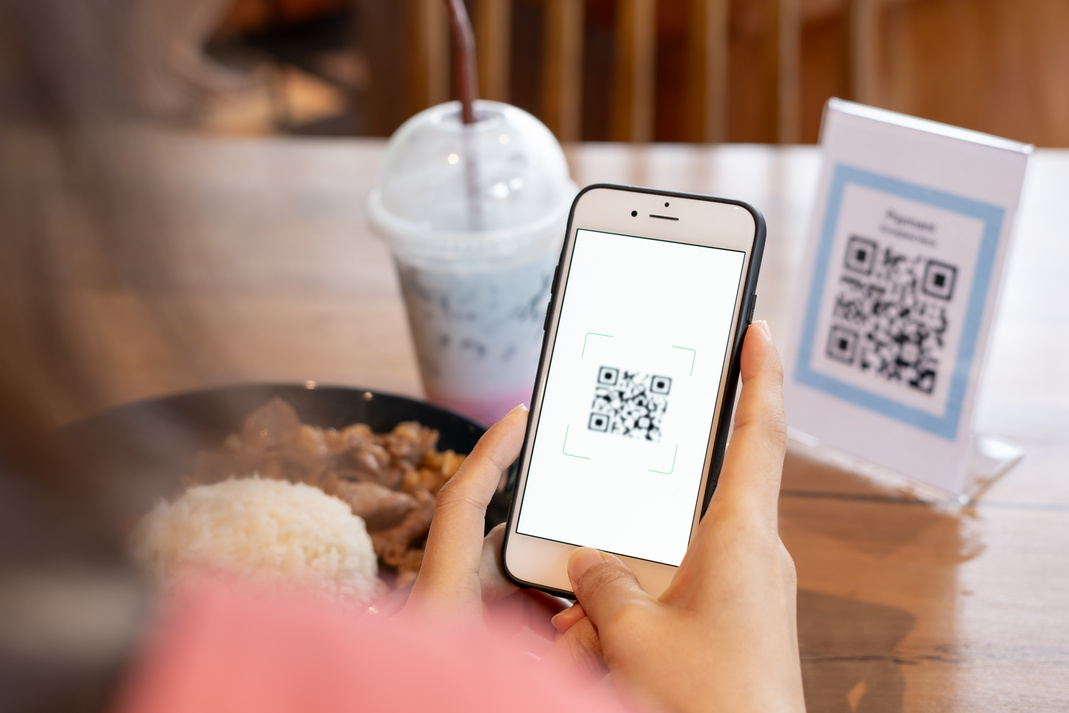 Woman use smartphone to scan QR code for order menu in cafe rest